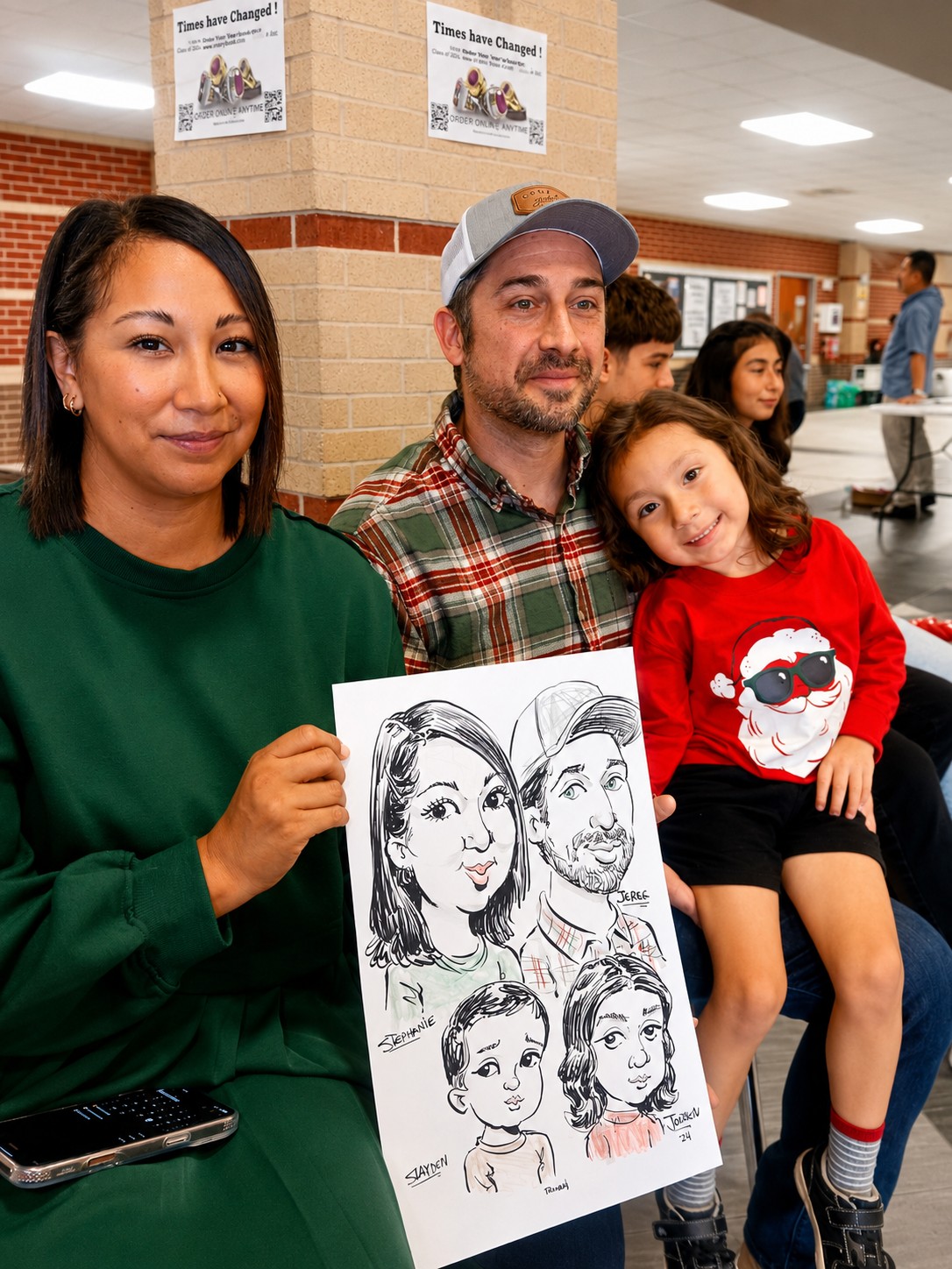 Family of four holding a group caricature at a company Christmas party