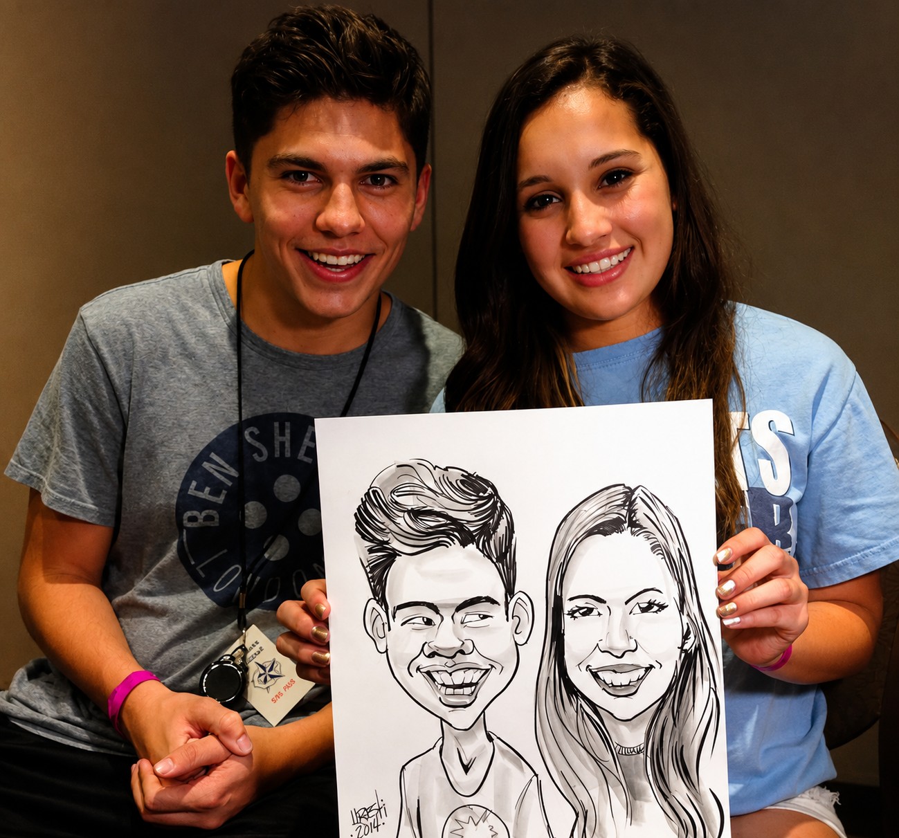 Young couple smiling while holding a black-and-white duo caricature by Eddie